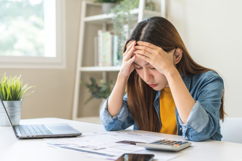 Financial owe asian woman sitting cover face with hands, stressed