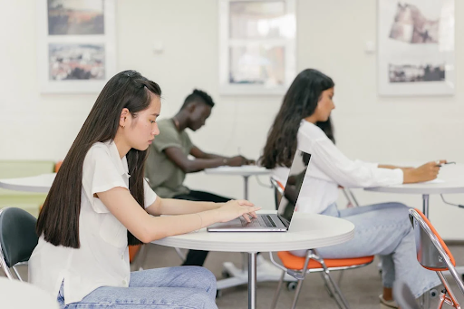 women typing on laptops