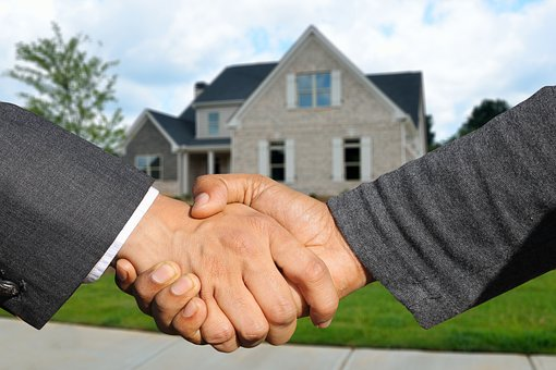 shaking hands in front of house