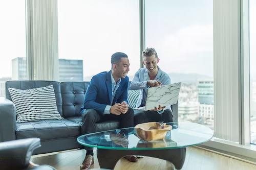 2 men looking at laptop in apartment