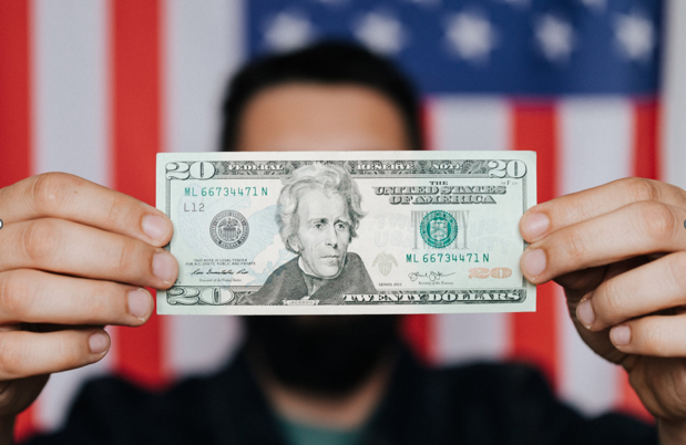 blurred man holding dollar bill