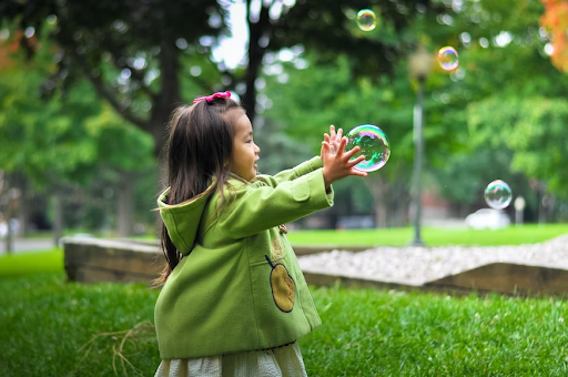 little girl catching a bubble