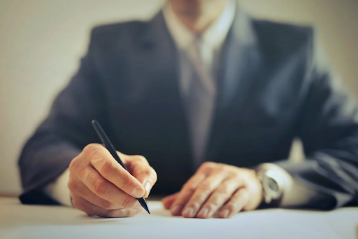 man signing document