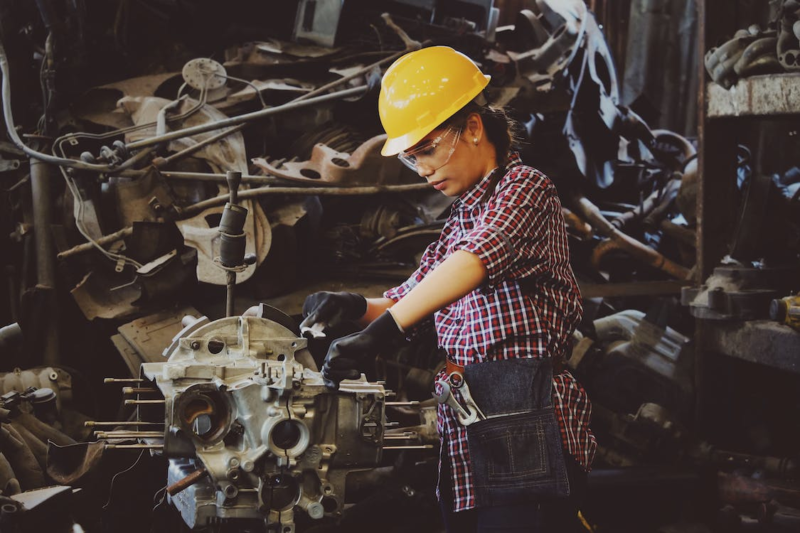 woman in hard hat working with machinery