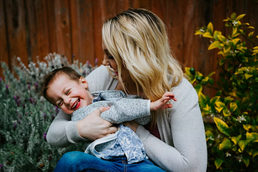 woman tickling laughing boy