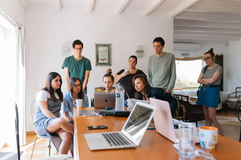 young people around a laptop