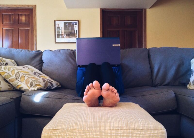 person on sofa with laptop