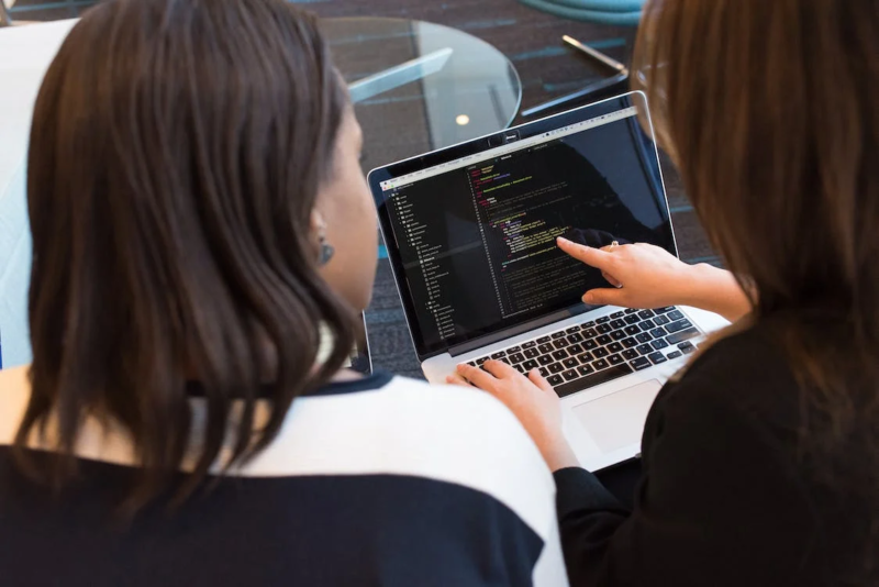 two ladies looking at laptop