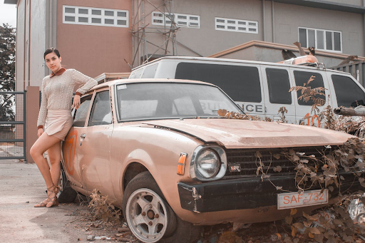 woman posing by abandoned car