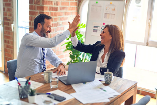 man and woman high five business meeting