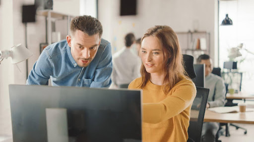 man and woman looking at computer screen
