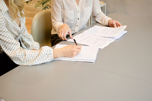 two ladies signing papers