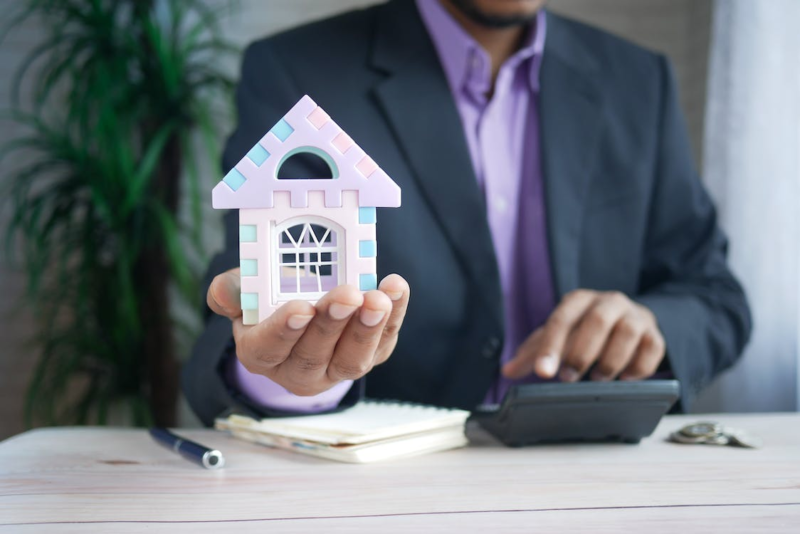 man holding toy house