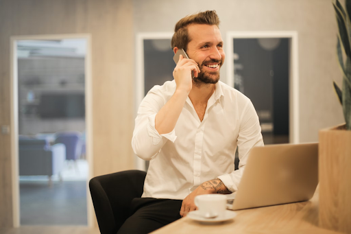 man with open laptop talking on phone
