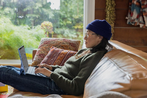 person sat on sofa using laptop