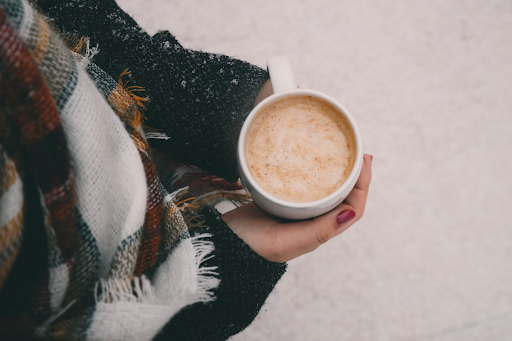 woman in scarf holding hot drink