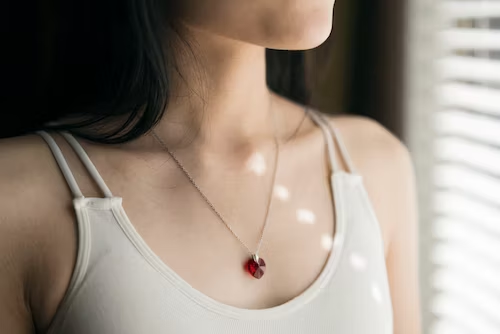lady wearing necklace with red stone