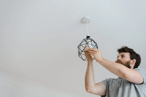 man screwing in light bulb
