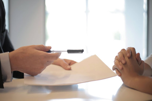man giving woman contract to sign