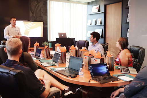 people sitting around table with laptops